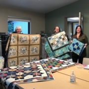 Anne Babuin, Diana Gunstone and Carlee Baker show off the beautiful new quilts.